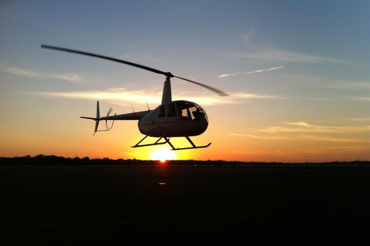 a helicopter flying over a city at sunset